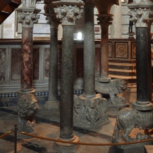 Lions circling crouching humans at the base of the pulpit.